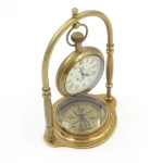 Brass clock on an arch with a compass