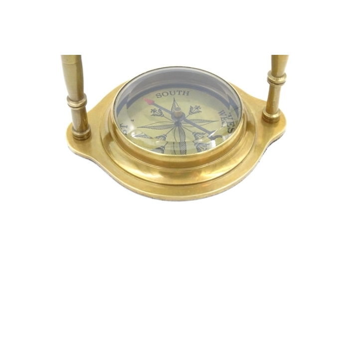 Brass clock on an arch with a compass